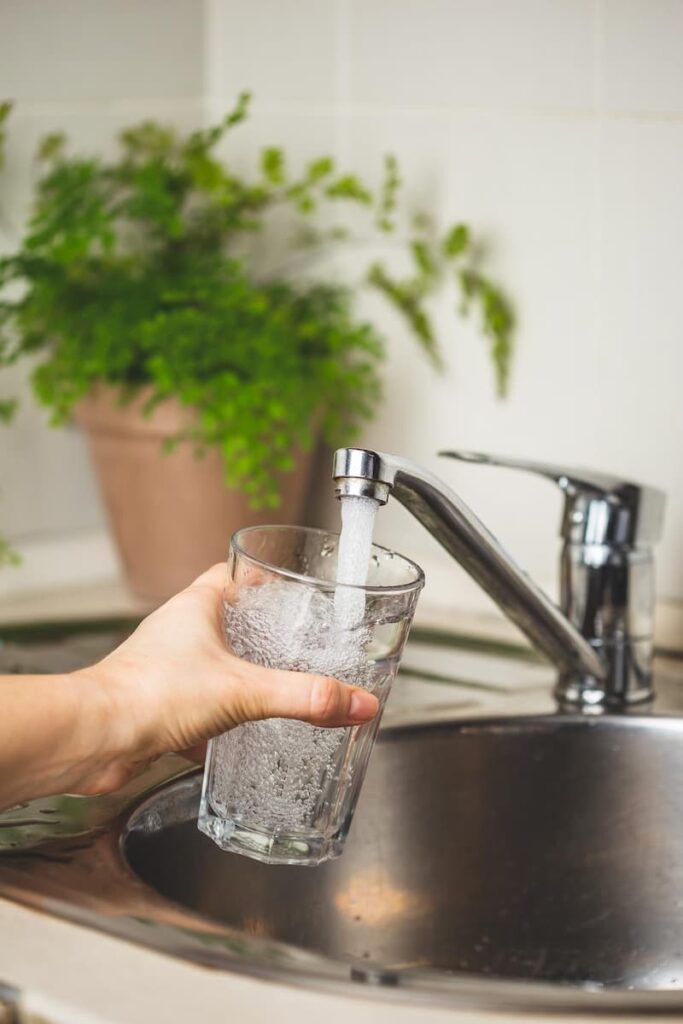 someone filling up water in the faucet