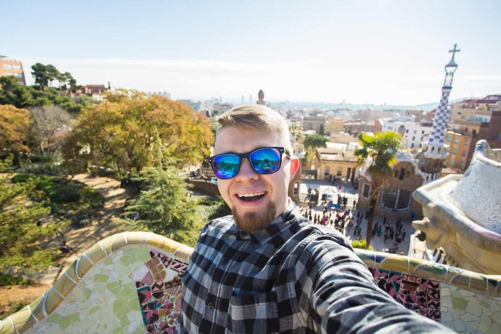 a man taking a selfie in a sunny Barcelona in April.