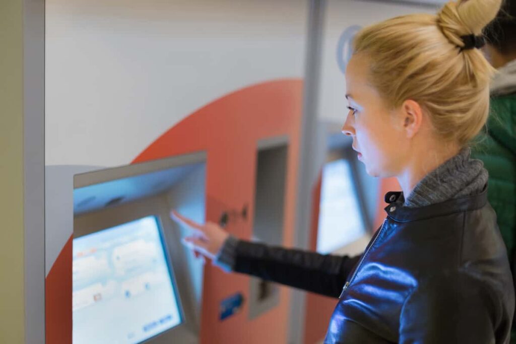 Woman buying metro ticket at vending machine