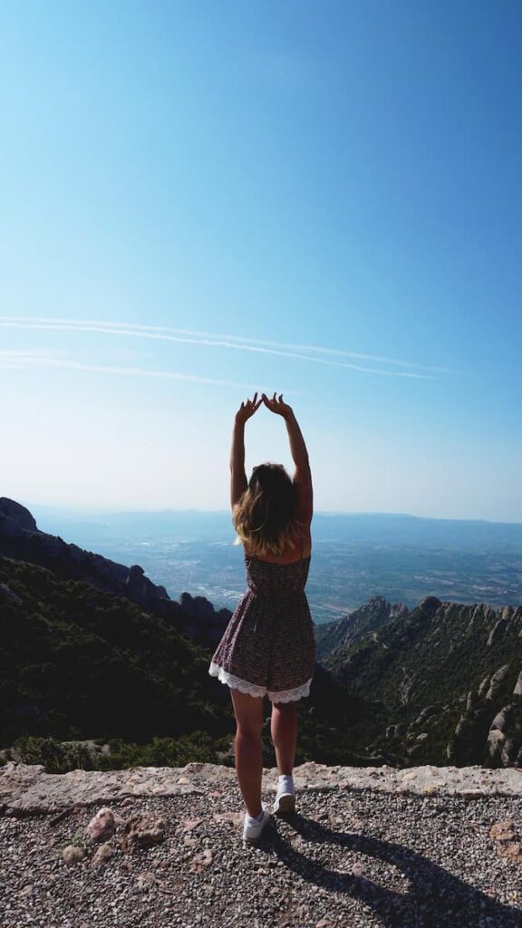 a woman enjoying the magnificent view of Montserrat Mountains while wearing comfortable shoes one of the best Barcelona travel tips