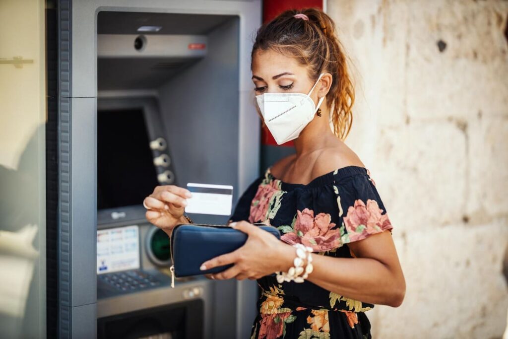 These Woman is making transactions thru her ATM so that she can avoid carrying cash.