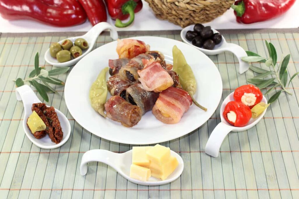 Different tapas in Serving spoon on a wooden mat in Bodega Pasaje 1986. One of the best Barcelona tapas restaurants.