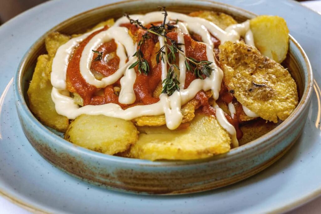 Patatas bravas are a typical preparation of the bars of Spain consisting of potatoes cut into large cubes, fried in olive oil and seasoned with salsa brava, which is a spicy sauce in Bar Velodromo. One of the best Barcelona tapas restaurants.