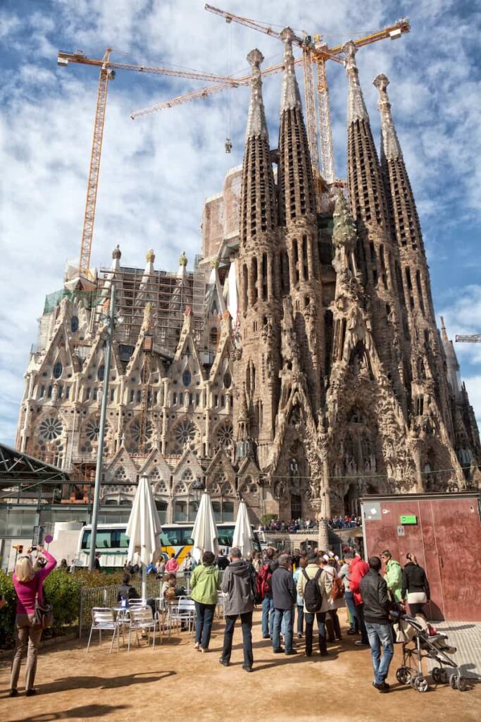 Tourists admiring the exterior of the La Sagrada Familia in barcelona with kids 