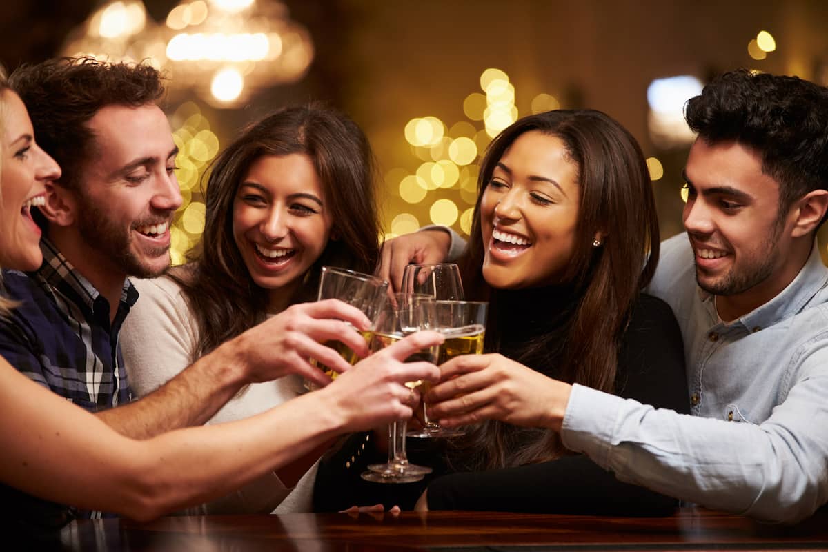 group of friends with drinks in one of the best areas to stay in Barcelona for nightlife