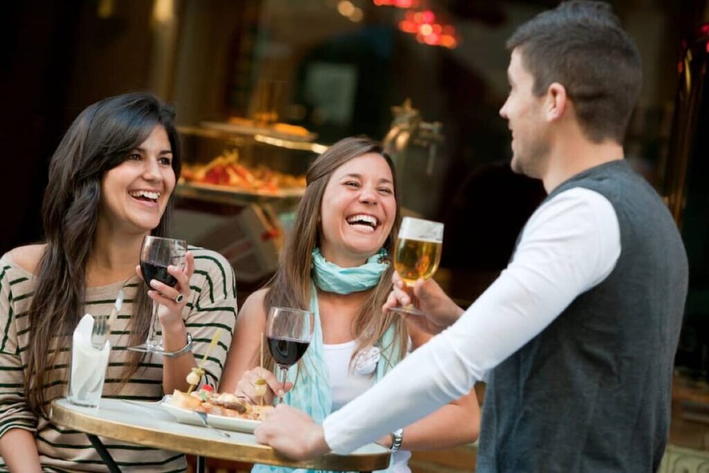 a group of tourist eating tapas and drinking wine 