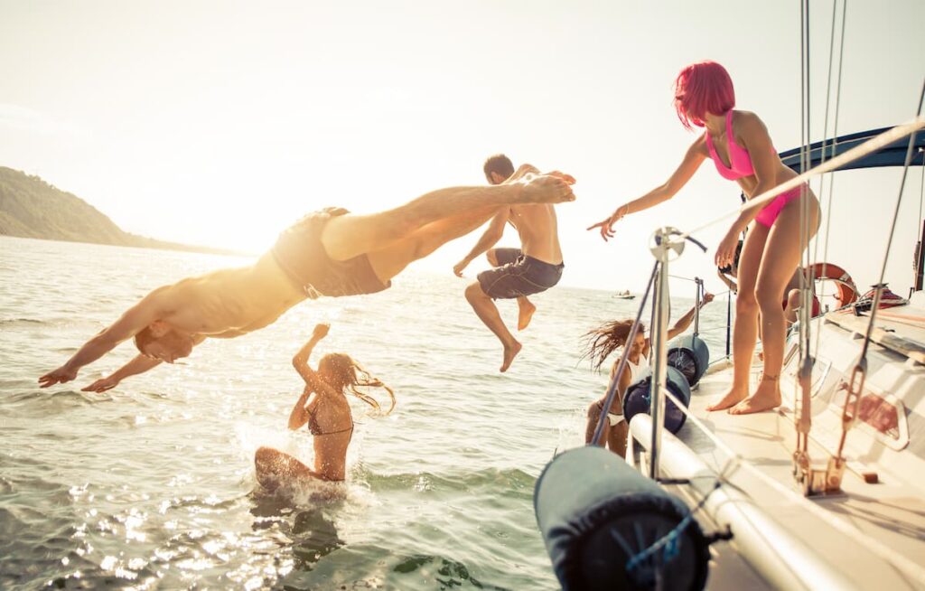Groups of friends having drinks and fun while sailing on one of the best Barcelona boat parties in Spain.