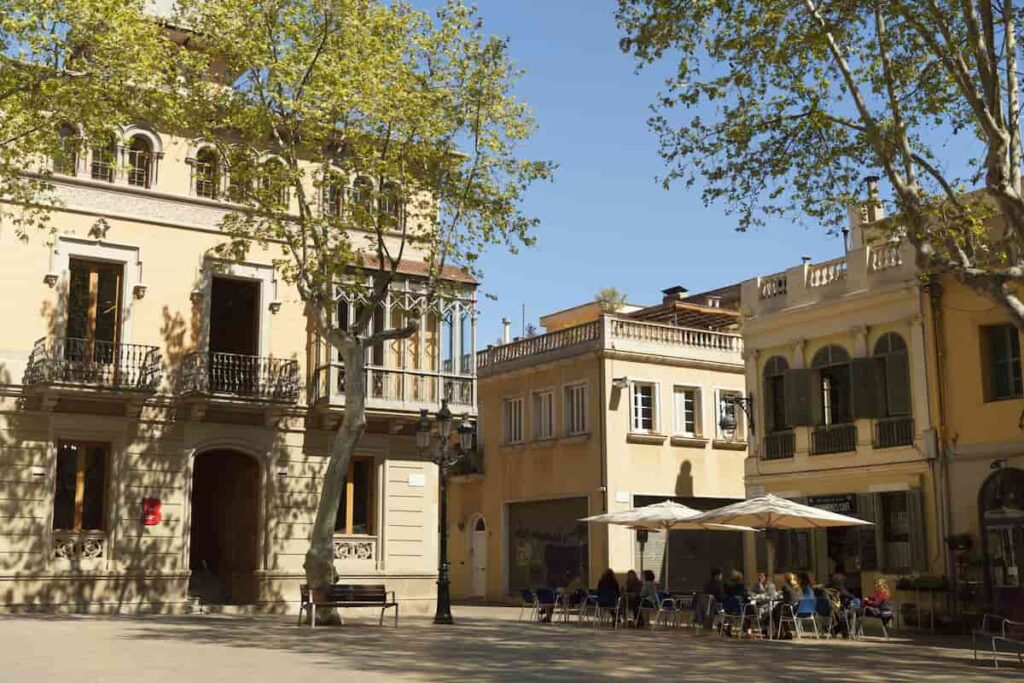 People enjoying summer terrace at Placa de la Concordia in Les Corts. One of the best Barcelona neighborhoods.