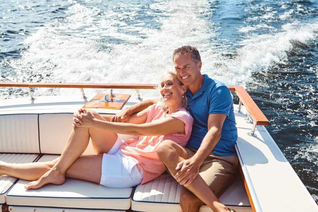 Old couple enjoying in a boat ride going to islands near Barcelona.