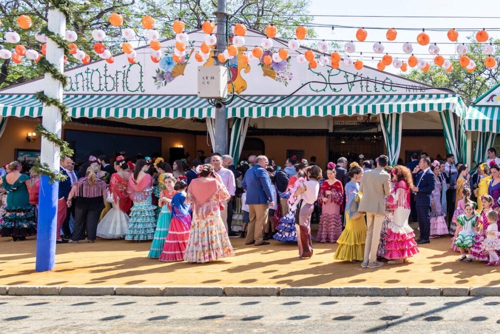 people at a caseta in traditional outfits during Feria in Seville, Spain