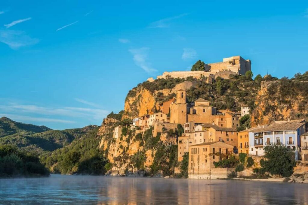 The riverside village of Miravet, with terracotta rooftops and a castle on the hill, is one of the best lesser-known Spanish towns to visit for a peaceful escape