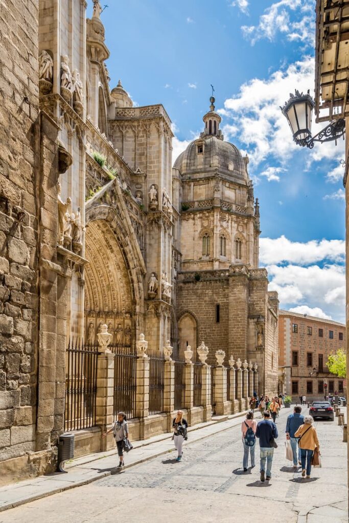 Visitors strolling past the grand Gothic facade of Toledo Cathedral – one of the cultural stops you’ll love on a one week itinerary Spain plan